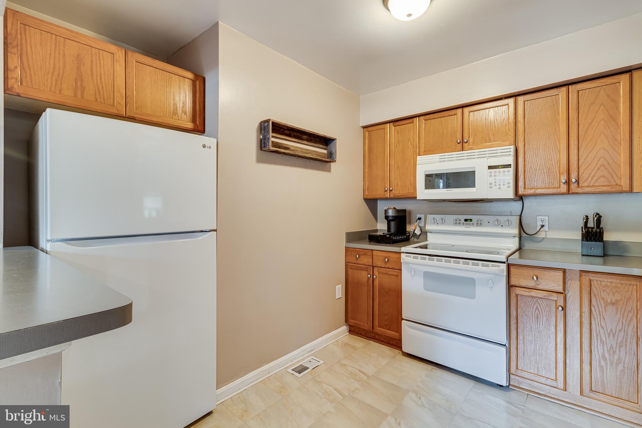 14305 Duckett Road Brandywine, MD 20613 - Photo 11 of 35 a kitchen with stainless steel appliances a refrigerator sink and white cabinets