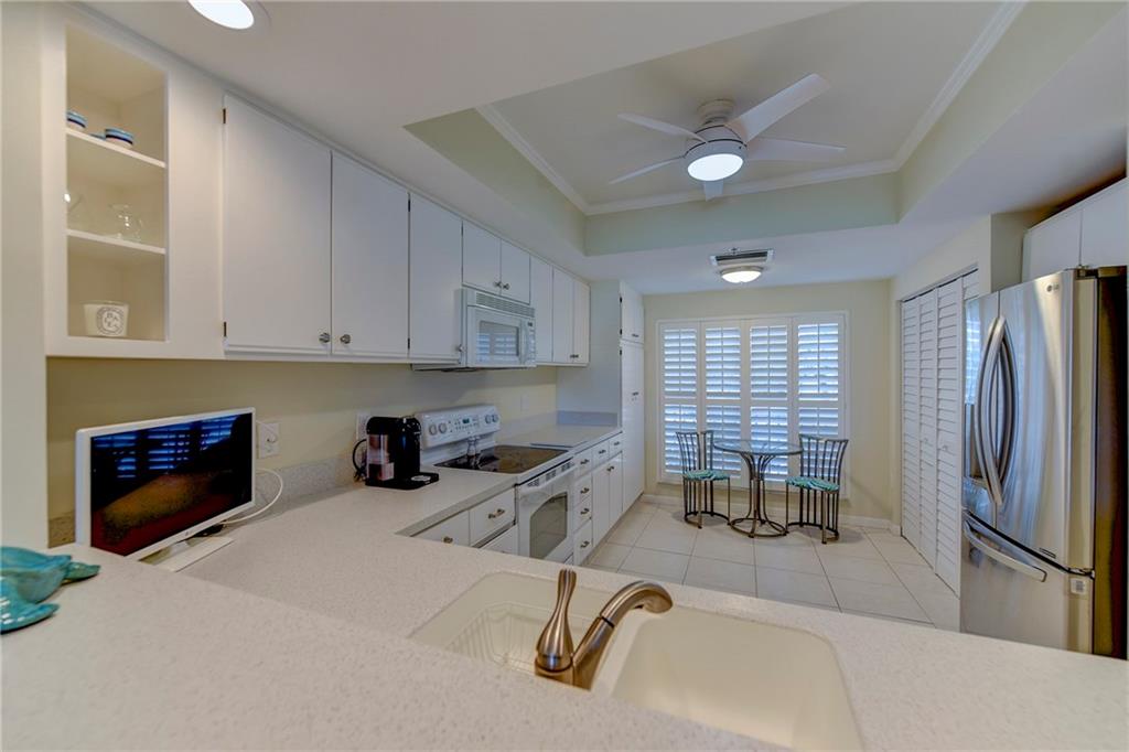 145 Northeast Edgewater Drive, Unit 4105 Stuart, FL 34996 - Photo 12 of 36 a kitchen with stainless steel appliances kitchen island granite countertop a refrigerator and a stove top oven
