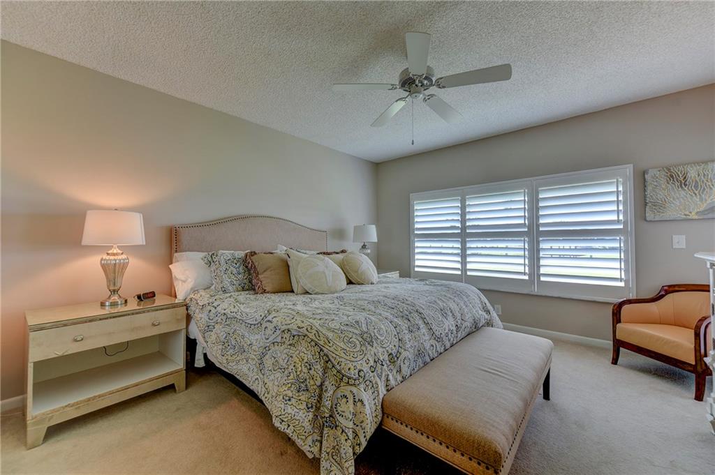 145 Northeast Edgewater Drive, Unit 4105 Stuart, FL 34996 - Photo 17 of 36 a bedroom with a bed and a couch