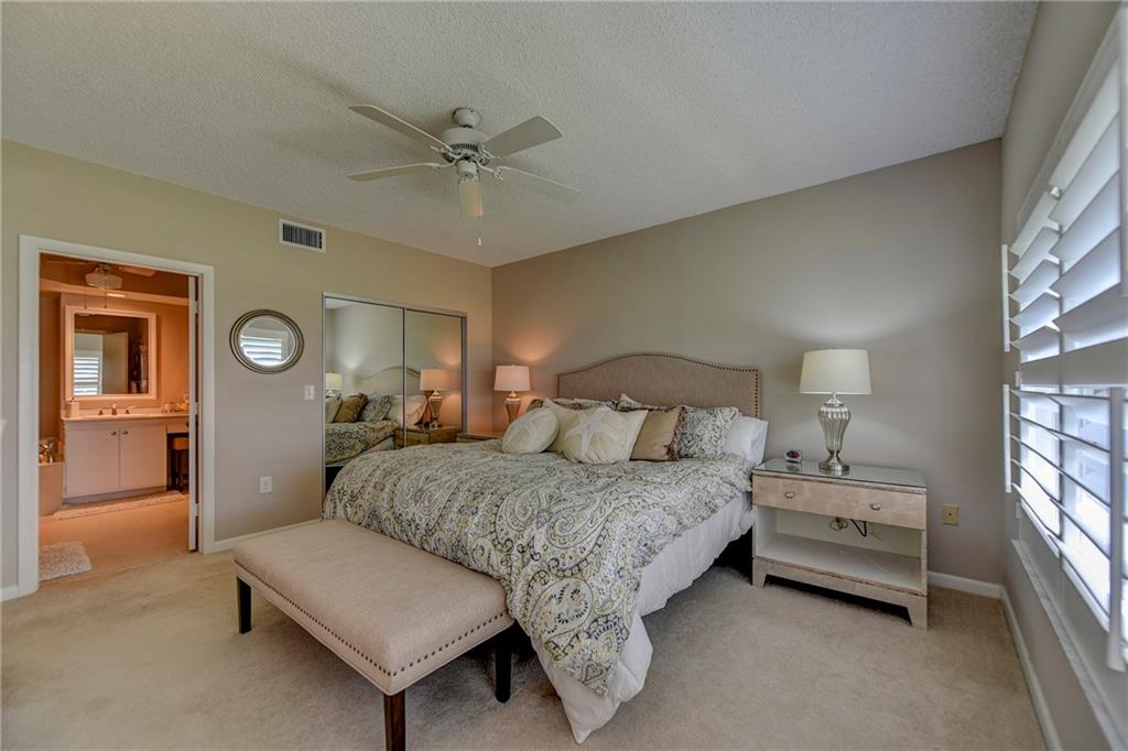 145 Northeast Edgewater Drive, Unit 4105 Stuart, FL 34996 - Photo 18 of 36 a bedroom with a bed and a chandelier
