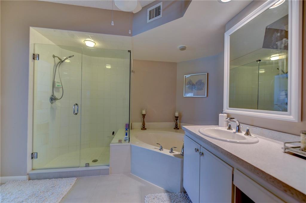 145 Northeast Edgewater Drive, Unit 4105 Stuart, FL 34996 - Photo 21 of 36 a bathroom with a tub sink and mirror