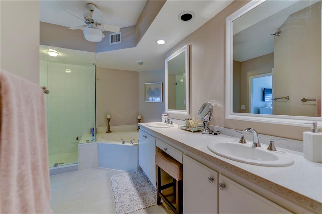 145 Northeast Edgewater Drive, Unit 4105 Stuart, FL 34996 - Photo 22 of 36 a bathroom with a sink double vanity granite tub and a mirror