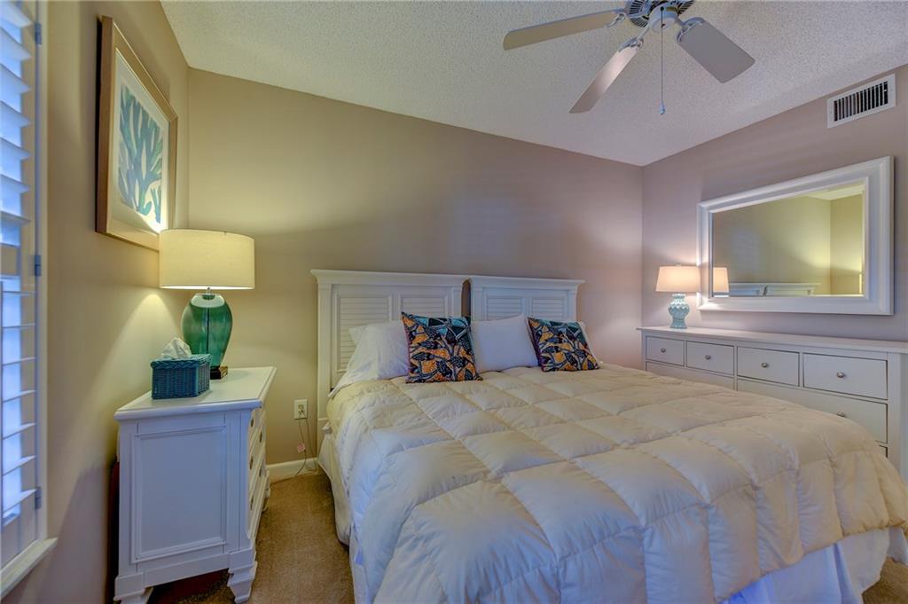 145 Northeast Edgewater Drive, Unit 4105 Stuart, FL 34996 - Photo 24 of 36 a bedroom with a bed and a chandelier