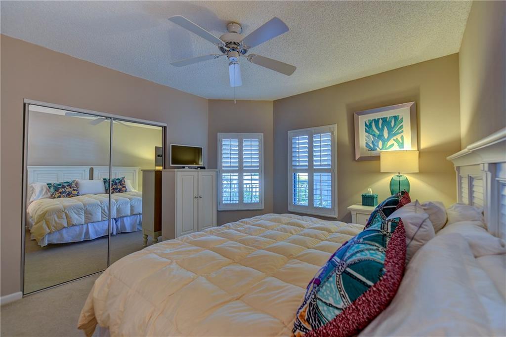 145 Northeast Edgewater Drive, Unit 4105 Stuart, FL 34996 - Photo 25 of 36 a bedroom with a large bed and a window