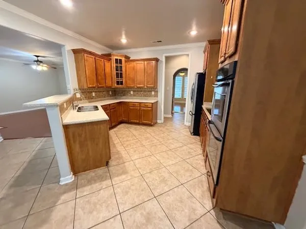a large kitchen with a sink a counter top space and stainless steel appliances