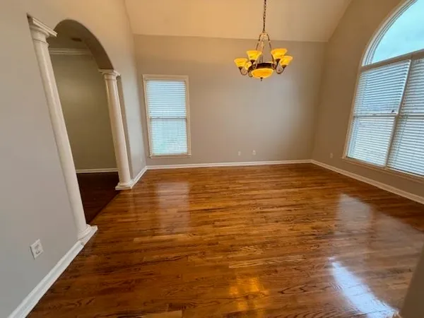 a view of a livingroom with wooden floor and a window