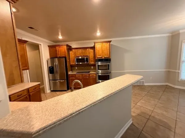 a kitchen with stainless steel appliances kitchen island granite countertop a refrigerator and a sink