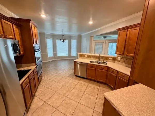 a kitchen with stainless steel appliances a stove a sink and a refrigerator