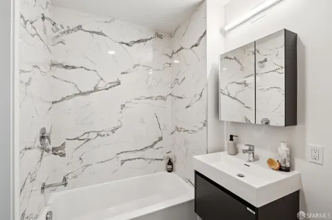 a bathroom with a sink mirror and a bathtub
