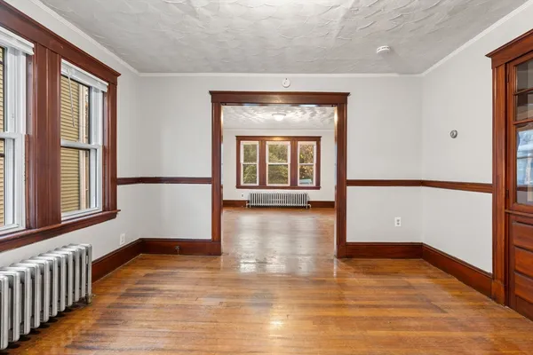 a view of a room with wooden floor and a window