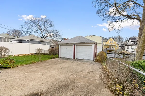 a front view of a house with a garden and trees
