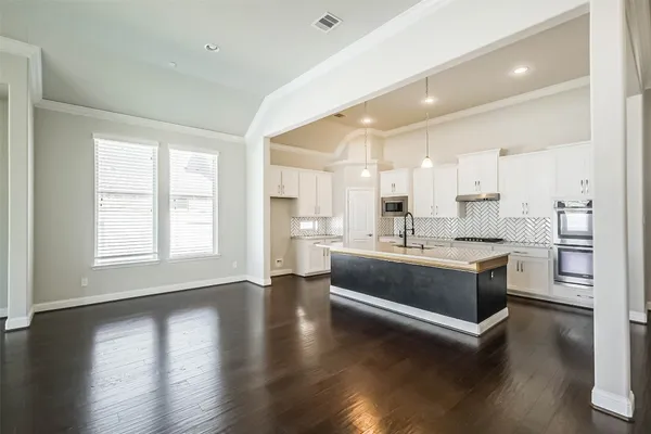 a large white kitchen with a stove a sink a refrigerator and a window