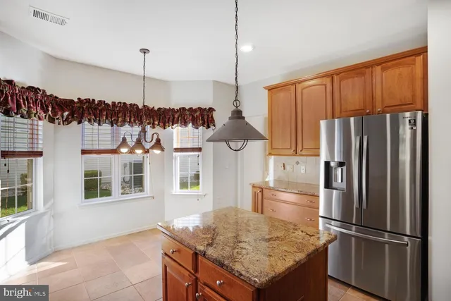 a kitchen with stainless steel appliances granite countertop a refrigerator a oven and a sink