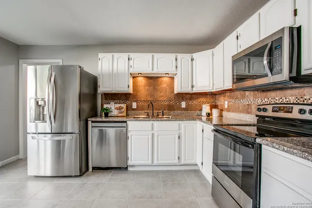 a kitchen with stainless steel appliances granite countertop a refrigerator stove and microwave