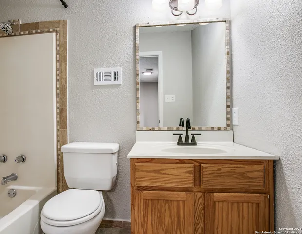 a bathroom with a sink vanity mirror and toilet