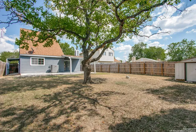 a view of a yard with a house and tree s