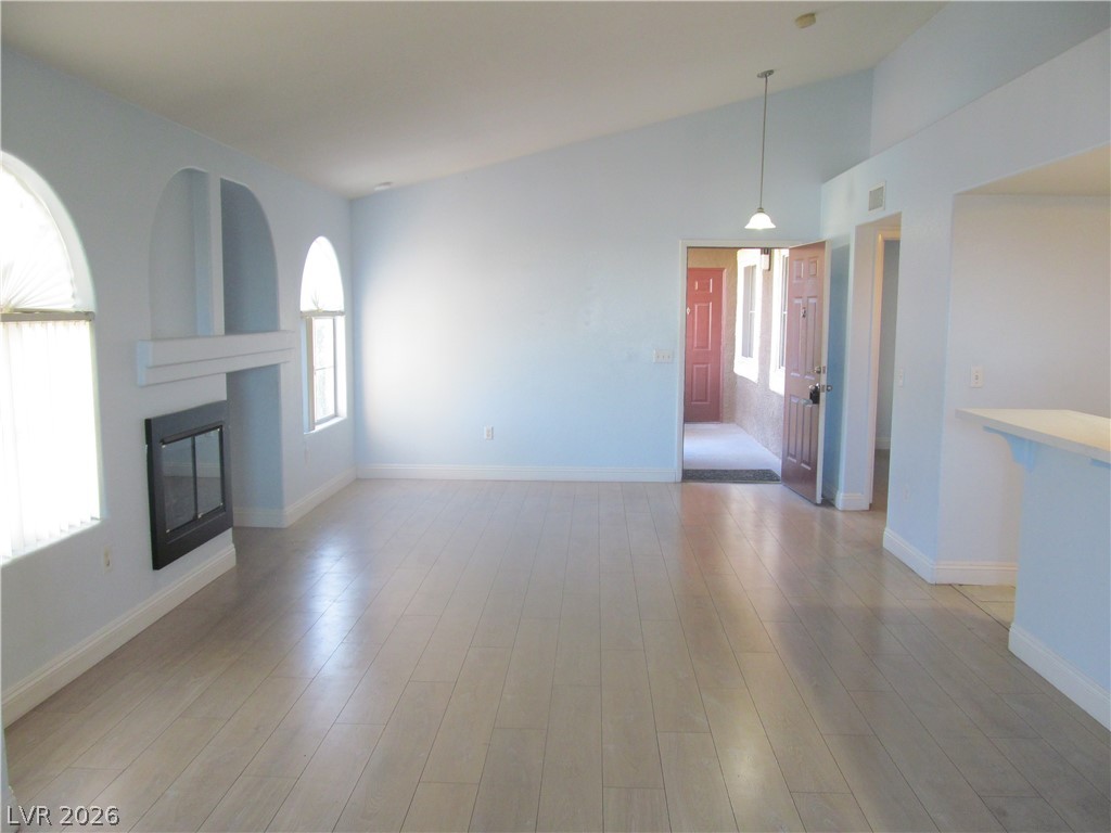 7950 West Flamingo Road, Unit 2048 Las Vegas, NV 89147 - Photo 11 of 24 A spacious living area with vaulted ceilings and a modern fireplace.