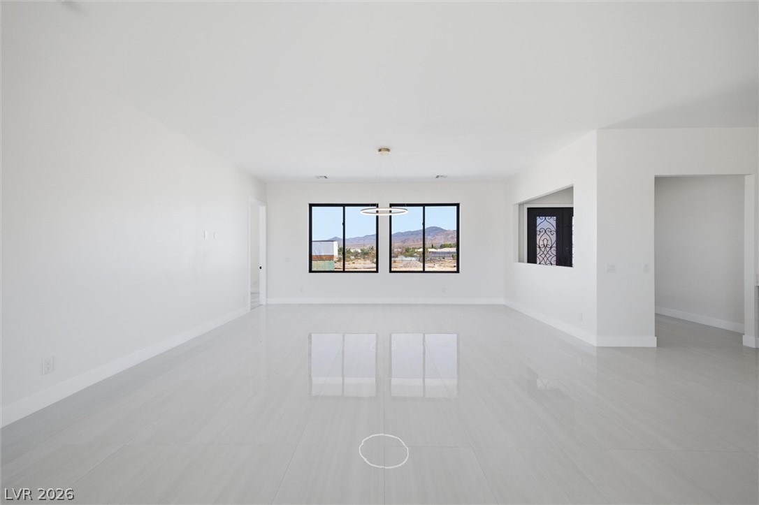 5910 East Kellogg Road Pahrump, NV 89061 - Photo 11 of 58 A spacious living area with sleek tile flooring offers expansive views of the mountains.