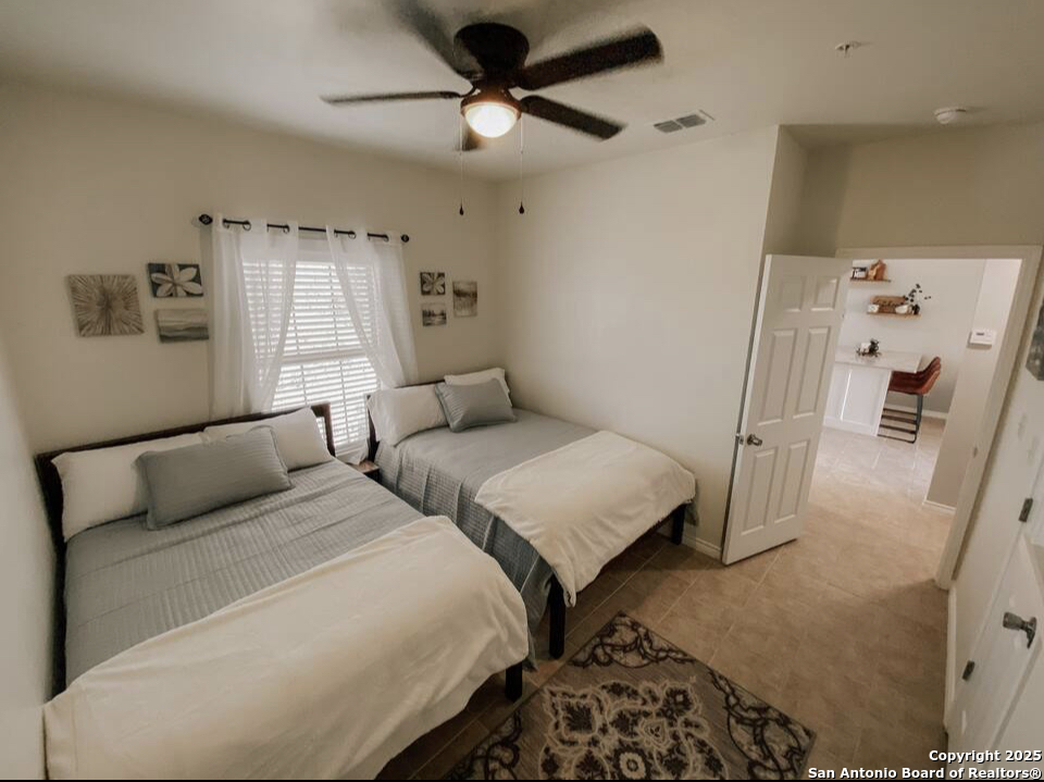 391 Riverside Drive, Unit 21 Eagle Pass, TX 78852 - Photo 10 of 11 a bedroom with two beds and a window