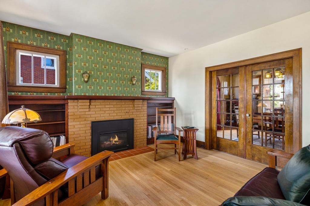 1059 North Riverside Avenue St. Clair, MI 48079 - Photo 7 of 27 Gleaming hardwood floors, a cozy gas fireplace, and antique lighting refurbished throughout create an inviting and warm atmosphere.
