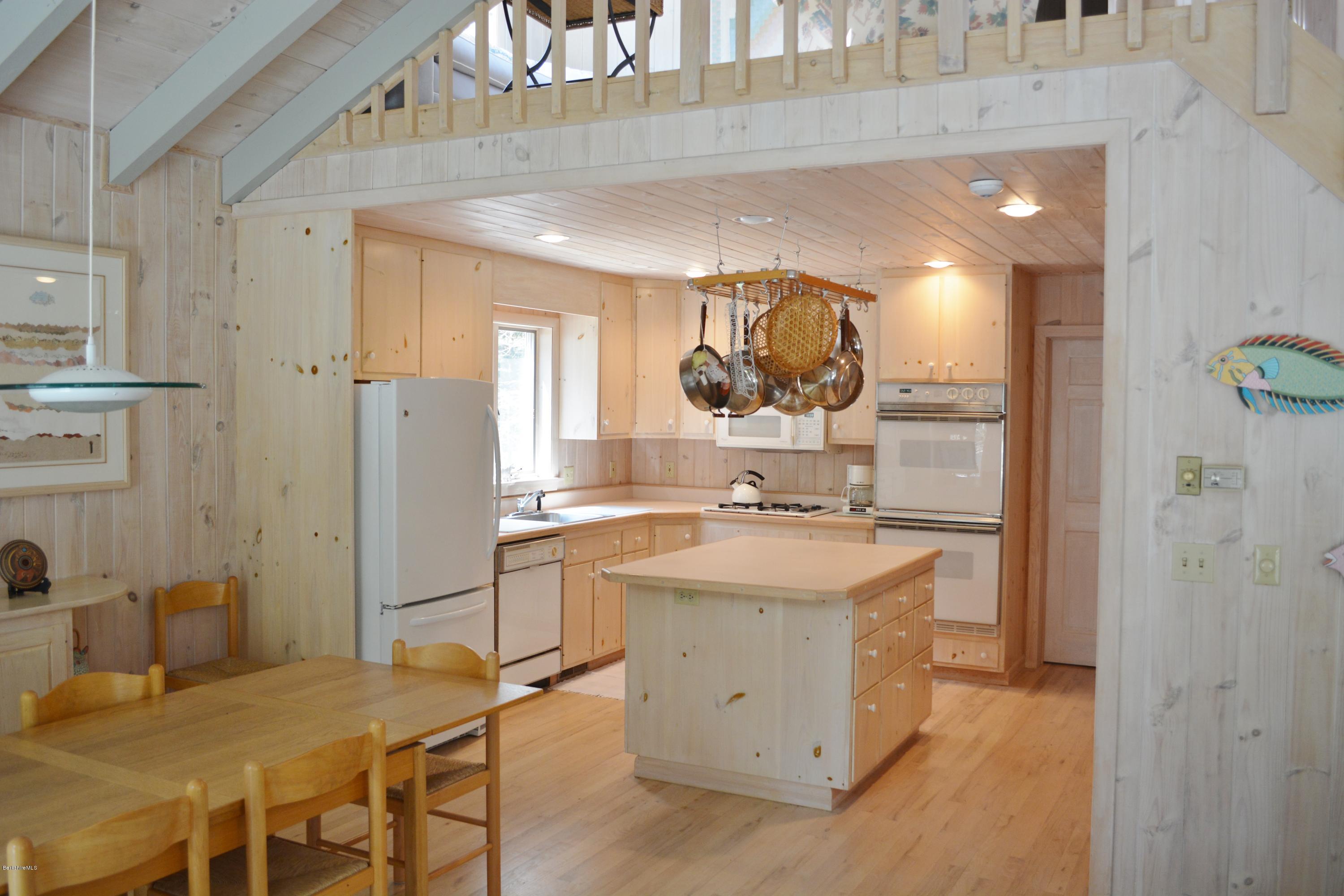 7 Sioux Road Becket, MA 01223 - Photo 4 of 22 a kitchen with a sink a refrigerator and chairs