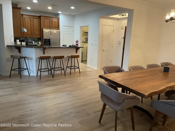 a view of a kitchen with kitchen island a table and chairs in it