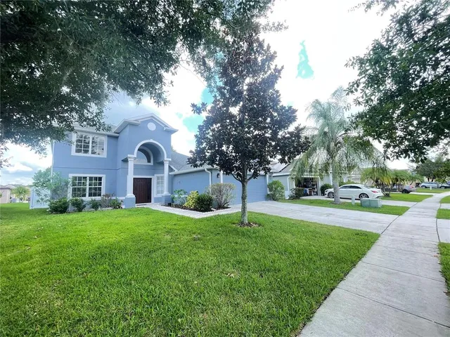 a front view of a house with a yard and trees
