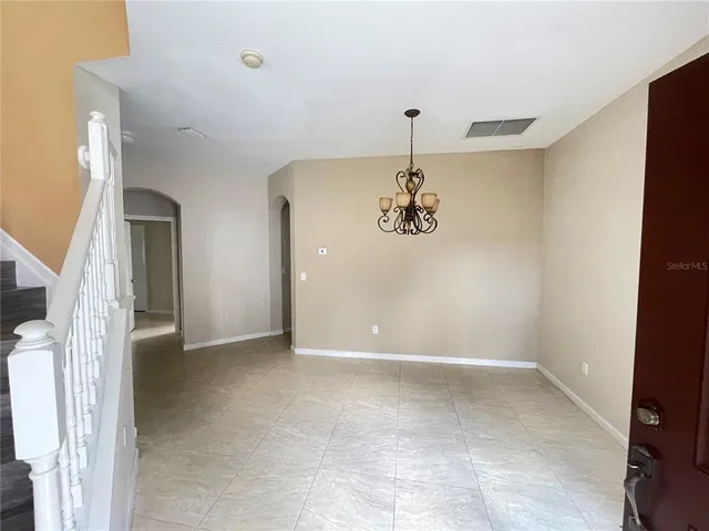 a view of a livingroom with a window and kitchen view