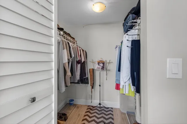 a view of walk in closet with clothes and shoes