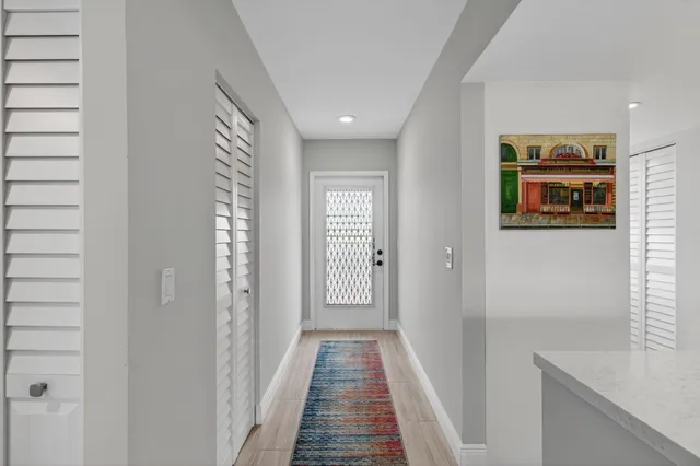 a view of a hallway with wooden floor and a bathroom