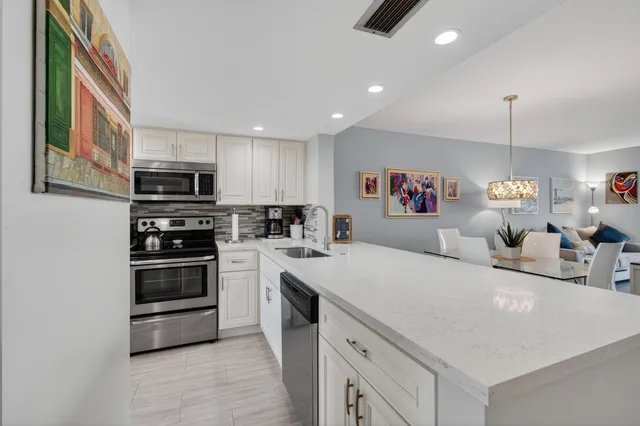 a kitchen with kitchen island a stove sink and a microwave