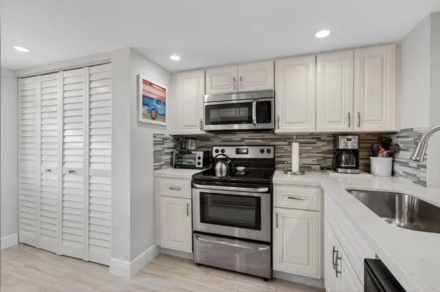 a kitchen with cabinets stainless steel appliances and wooden floor