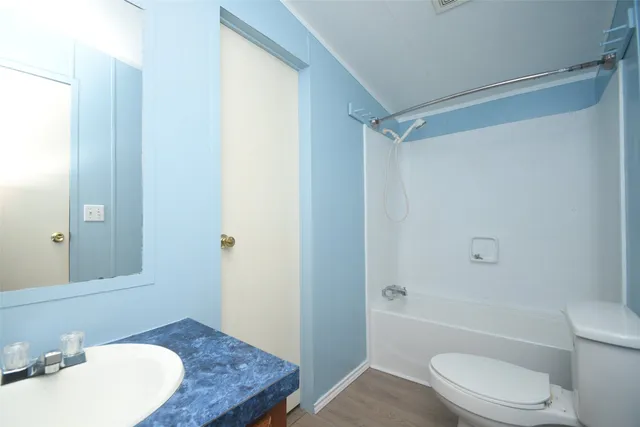 a bathroom with a granite countertop sink toilet and shower