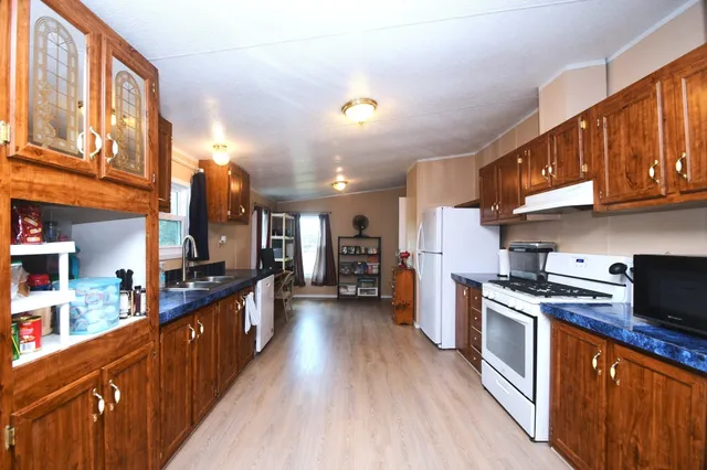 a kitchen with stainless steel appliances granite countertop wooden cabinets a stove top oven a sink and dishwasher