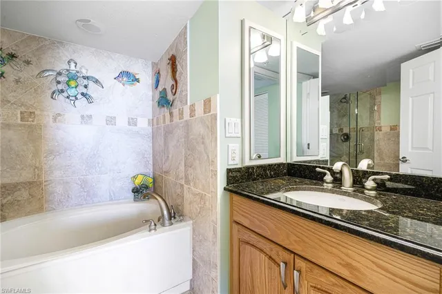a bathroom with a granite countertop bathtub shower sink and toilet