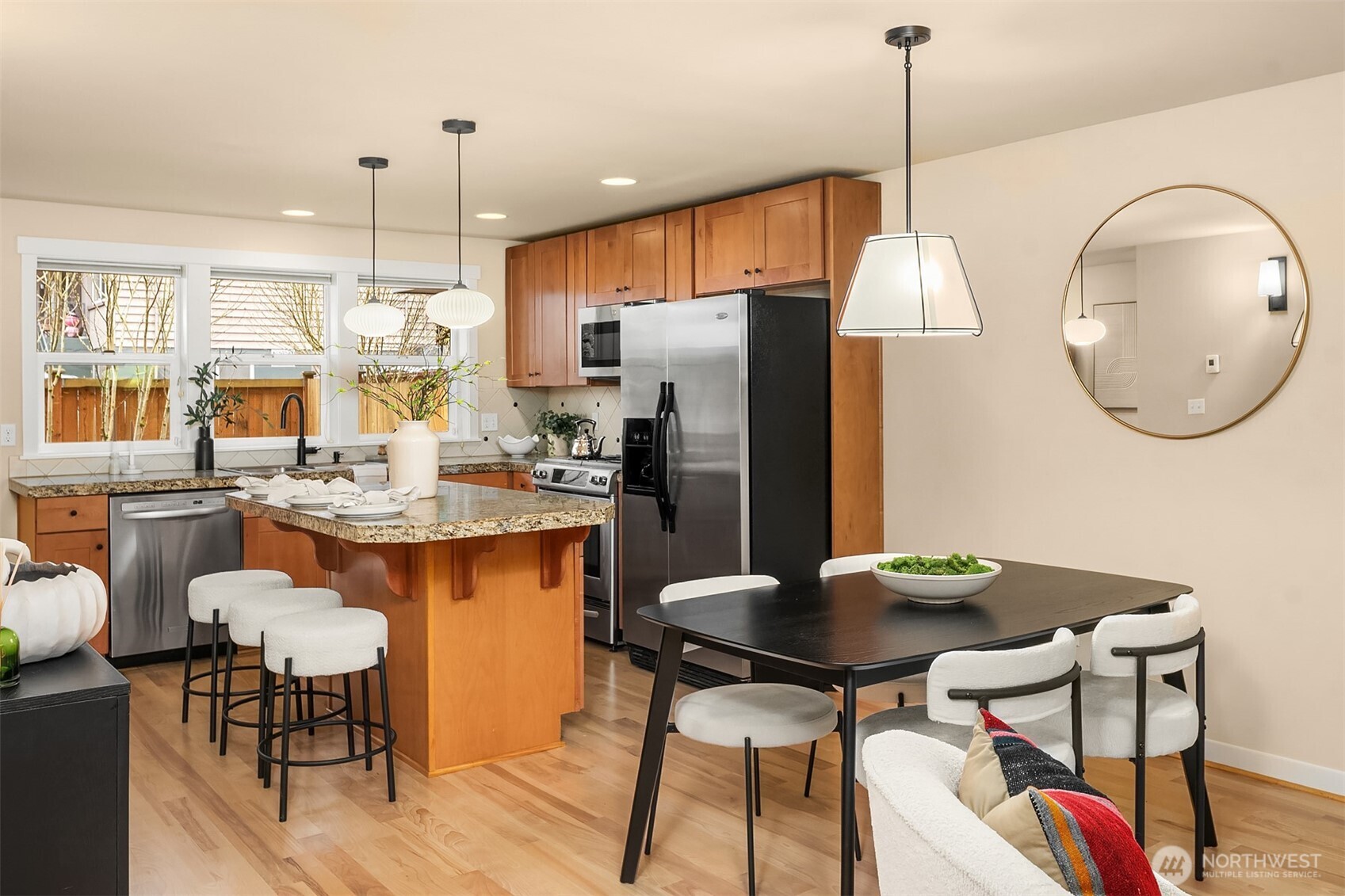 3615 Albion Place North, Unit B Seattle, WA 98103 - Photo 8 of 30 a kitchen with stainless steel appliances kitchen island granite countertop a table chairs and a refrigerator