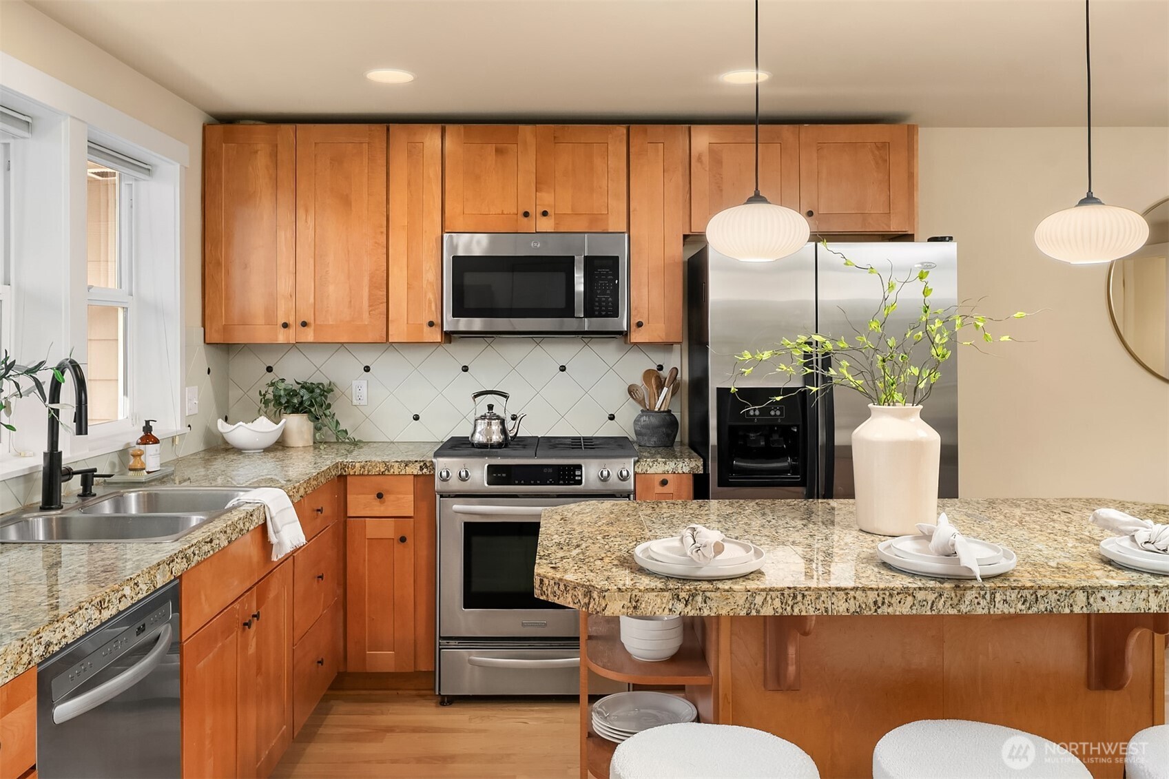3615 Albion Place North, Unit B Seattle, WA 98103 - Photo 10 of 30 a kitchen with kitchen island granite countertop a sink cabinets and stainless steel appliances
