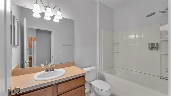 a bathroom with a granite countertop sink toilet a mirror and shower