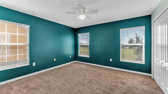 a view of an empty room with a window and a ceiling fan