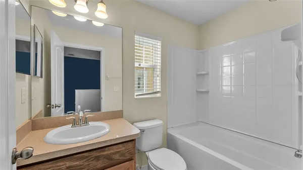 a bathroom with a sink vanity granite tub and a mirror