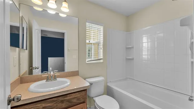 a bathroom with a sink vanity granite tub and a mirror