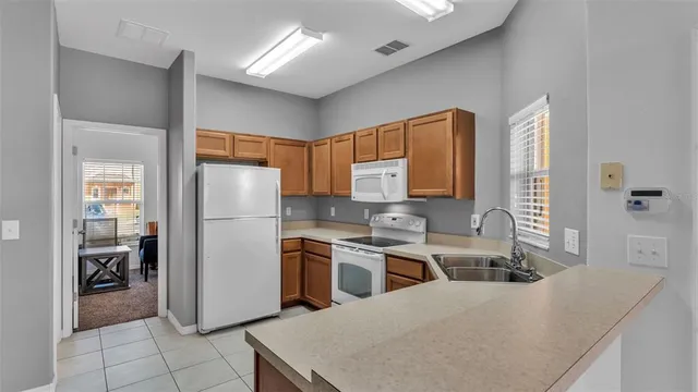 a kitchen with stainless steel appliances granite countertop a refrigerator a sink a stove and island