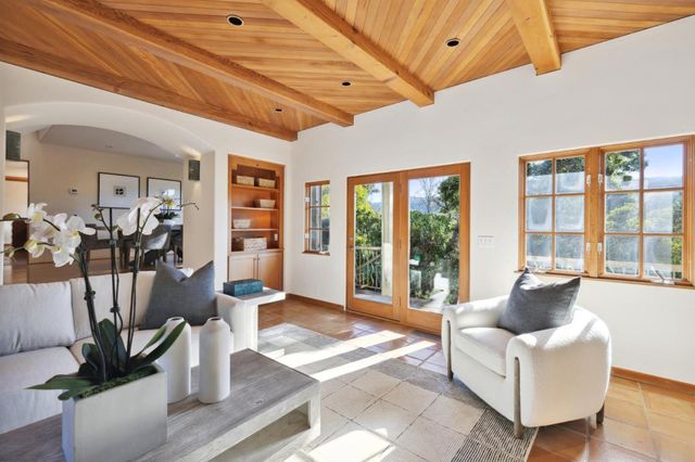 a living room with furniture a flat screen tv and a floor to ceiling window