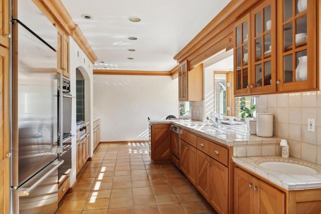 a large kitchen with stainless steel appliances granite countertop a sink and cabinets