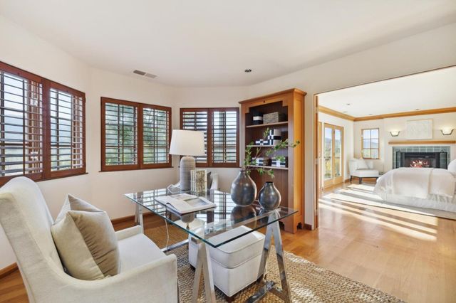 a living room with fireplace furniture and a large window