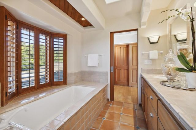 a spacious bathroom with a granite countertop tub sink and mirror
