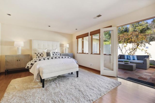 a bed sitting in a spacious bedroom next to a window