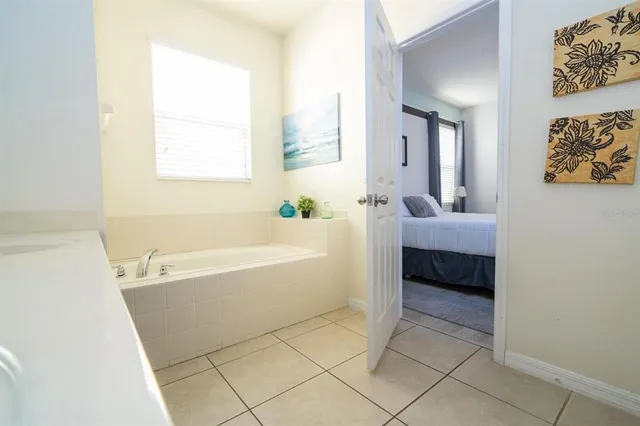 a spacious bathroom with a tub sink and mirror