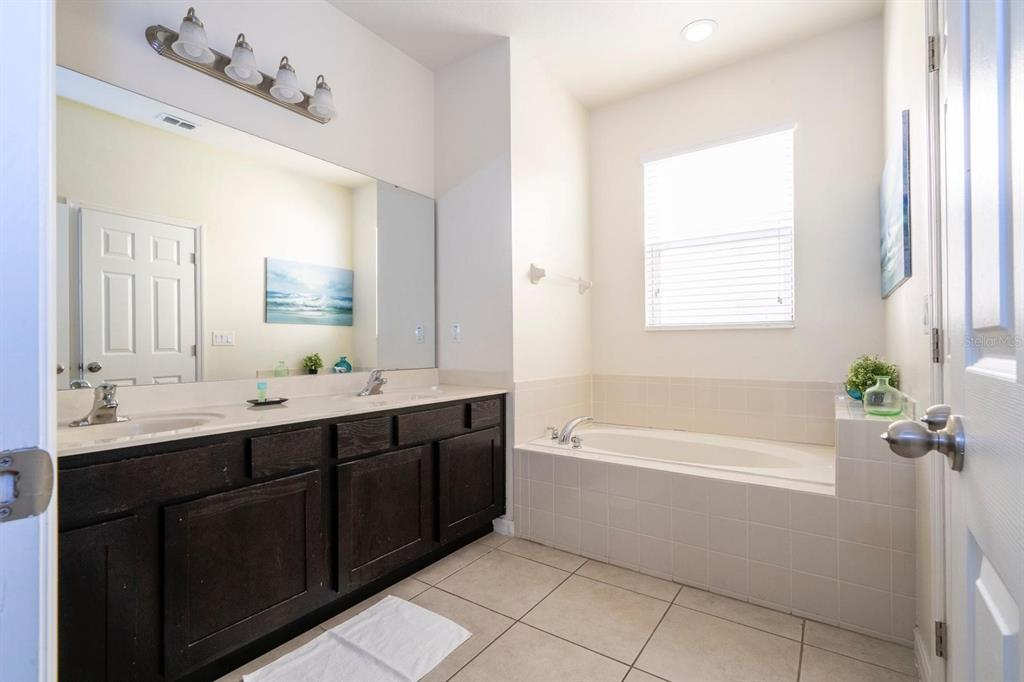2625 Santosh Cove Kissimmee, FL 34746 - Photo 20 of 29 a bathroom with a tub sink and mirror