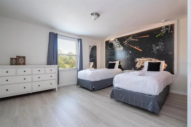 a bedroom with bed and wooden floor